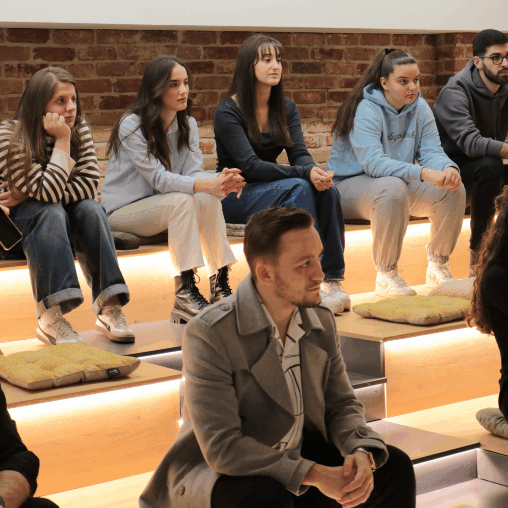 Students sitting at AnchorzUp amphitheater listening to Jeta Zagragjas' talk during their visit at AnchorzUp